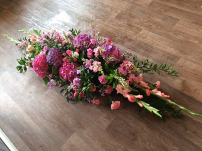 Coffin spray (Shades of pink) - A beautiful arrangement of cottage garden style flowers in shades of pink. Other colours are availble in this design. Please contact us to discuss your requirements.  Flower and design may vary from image shown. We deliver to all funeral directors in our locality including Gosport, Fareham, Lee-on-the-Solent, Stubbington, Titchfiled and their surrounding areas. All of our floral designs are made by our highly trained and skilful florists on site. We are also aware that some customers have special requirements that we are always available to consult in order to meet all of your floral needs. If you require any more information then please do not hesitate to contact us. Contact details as follows, you can call us on 023 92520123, use our contact page through our website to send us a message or even come into the shop and see us face to face.
