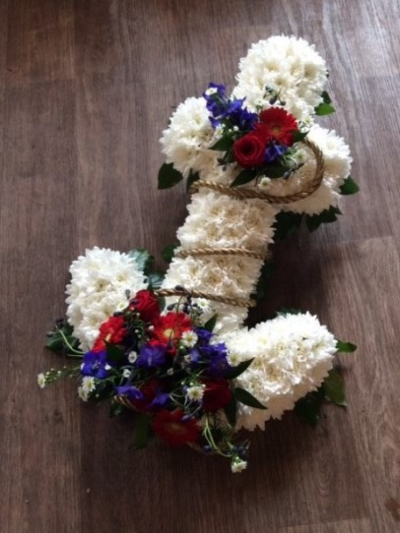 Anchor Funeral Tribute Red White and Blue - Anchor funeral tribute in red, white and blue. Patriotic colours and nautical The anchor design comes with a foliaged edge, base with white chrysanthemum flowers and beautiful floral posies of red, white and blue flowers. This design is available  in 2 ft and 3 ft sizes. All of our floral arrangements are made by our talented skilful florists on site. Please allow 3 working days for us to design and made this funeral tribute for you. We deliver to all local funeral directors covering Gosport, Fareham, Stubbington, Lee-on-the-Solent and Titchfield. If you would like any advice or would like to speak with us then please call 023 92520123 or you can send us a message through our contact page. Although our website is vast and varied we are also aware that some customers may have special requirements that we are always available to consult in order to meet all of your floral needs. Our contact details are as follows. You can call us on 023 92520123. use our contact page to send us a message or even come into the shop and see us face to face.